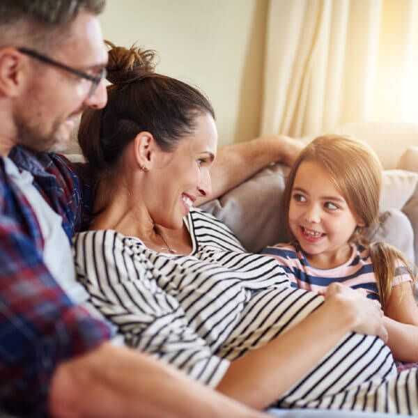 Family is sitting together and happy because they are expecting a baby