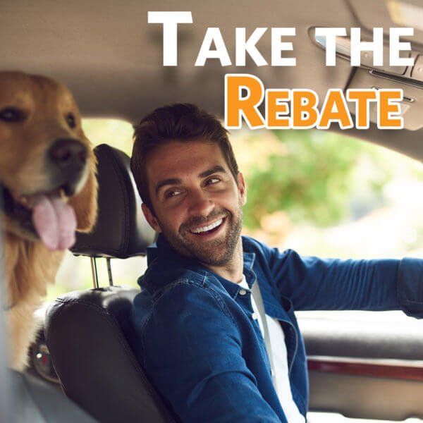 Smiling Man driving in car with dog