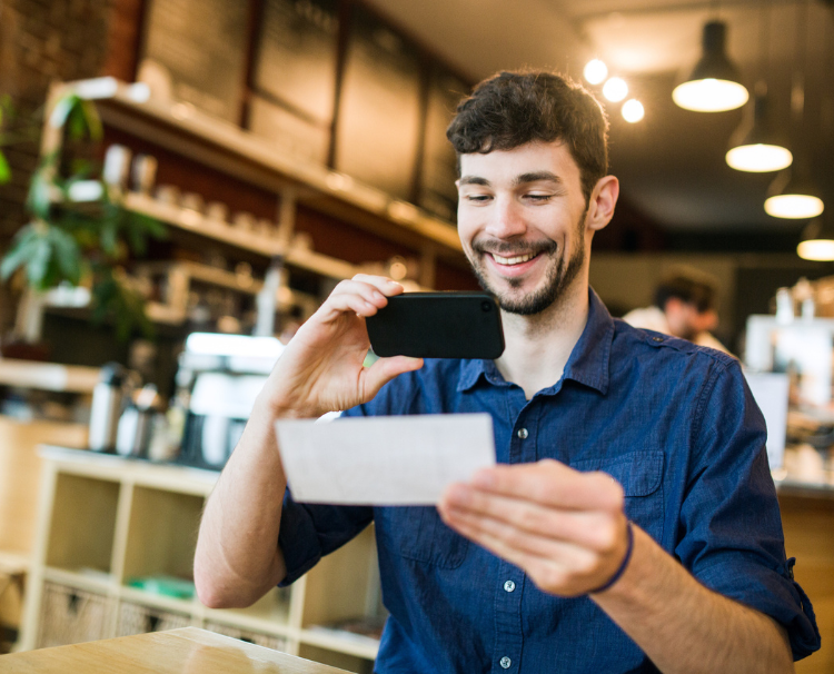 Man taking picture of check with his mobile phone