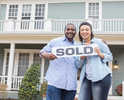 Couple holding sold sign