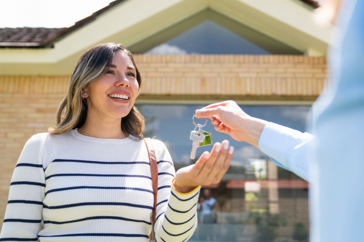 Woman being handed keys to new home