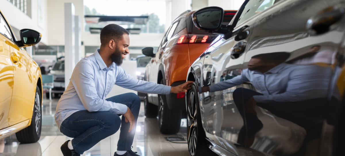 Adult male looking at car in dealership