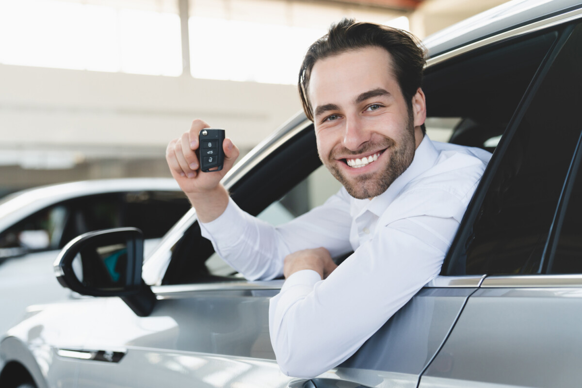 Male holding new keys to new car