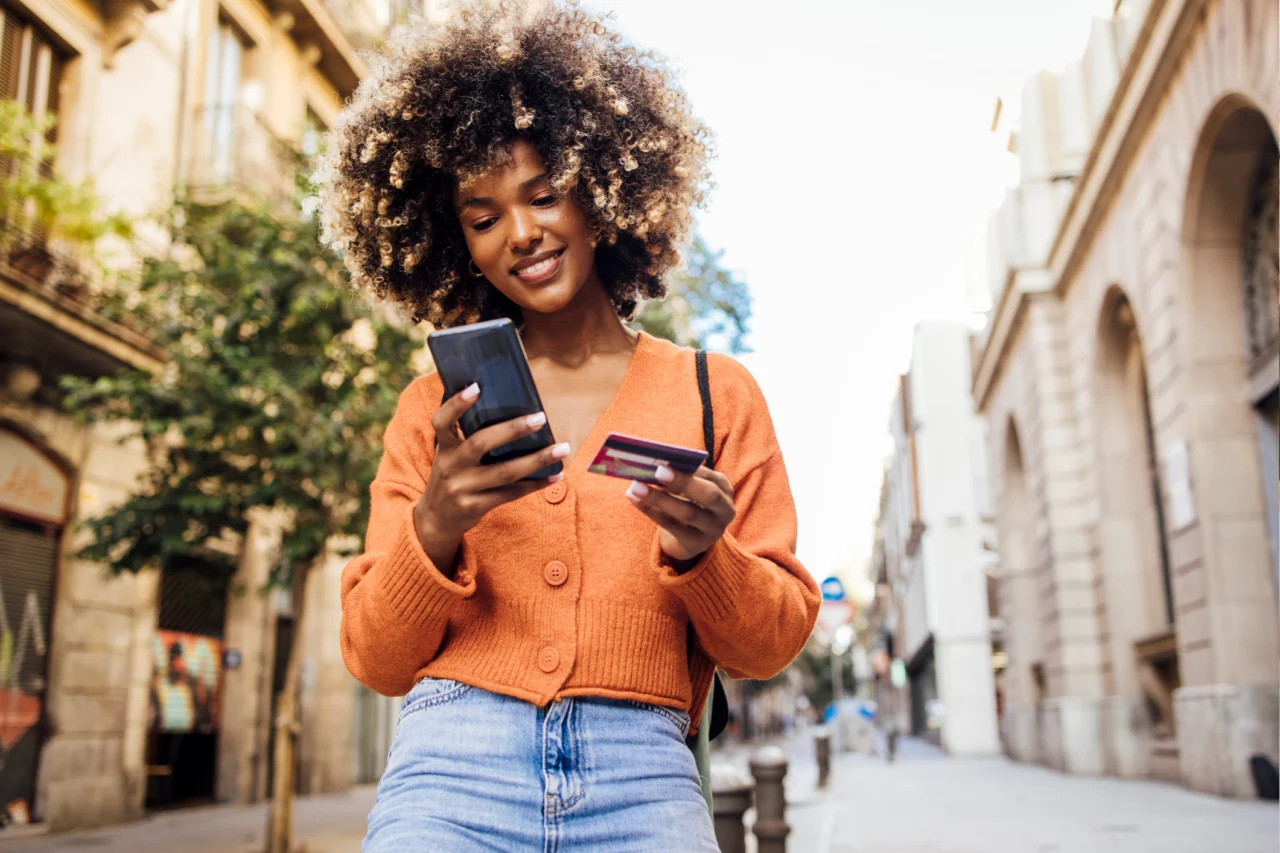 Woman walking with phone and card