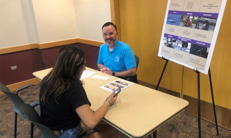 NuMark Credit Union Staff member with a CREO DuPage Student at one of the Mad City Money stations